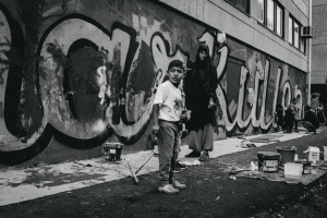 Photo of a kid who has been painting a wall, and his mother by futuro berg